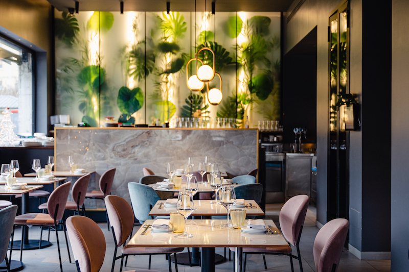 La sala principale con la parete botanica retroilluminata e i pendenti in ottone
